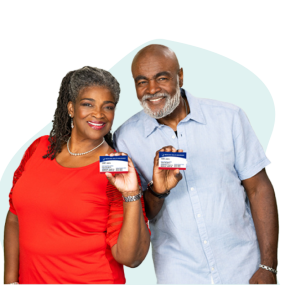 Pareja afroamericana sonriendo y sosteniendo tarjetas de Medicare