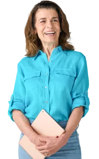 mujer blanca sonriente con una camisa azul y jeans sosteniendo una tableta
